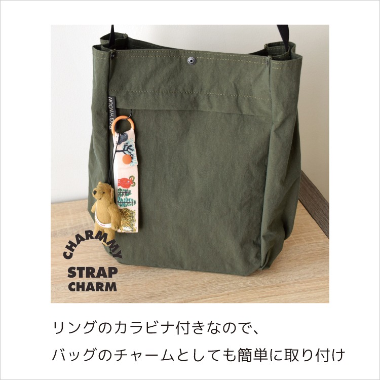 バッグにカラビナで取り付けたチャーミーストラップチャームとクマのぬいぐるみの使用例